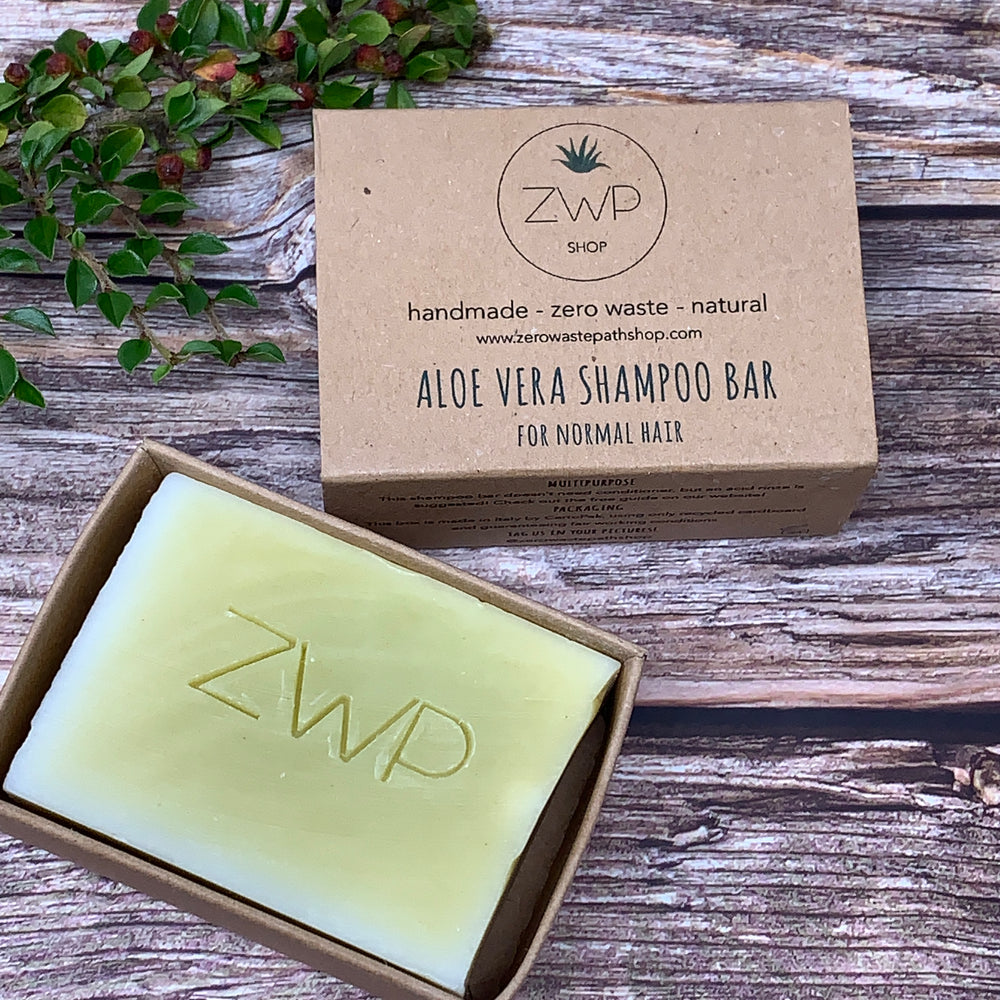 Brown box that says &quot;aloe vera shampoo bar for normal hair&quot; and solid shampoo bar inside box