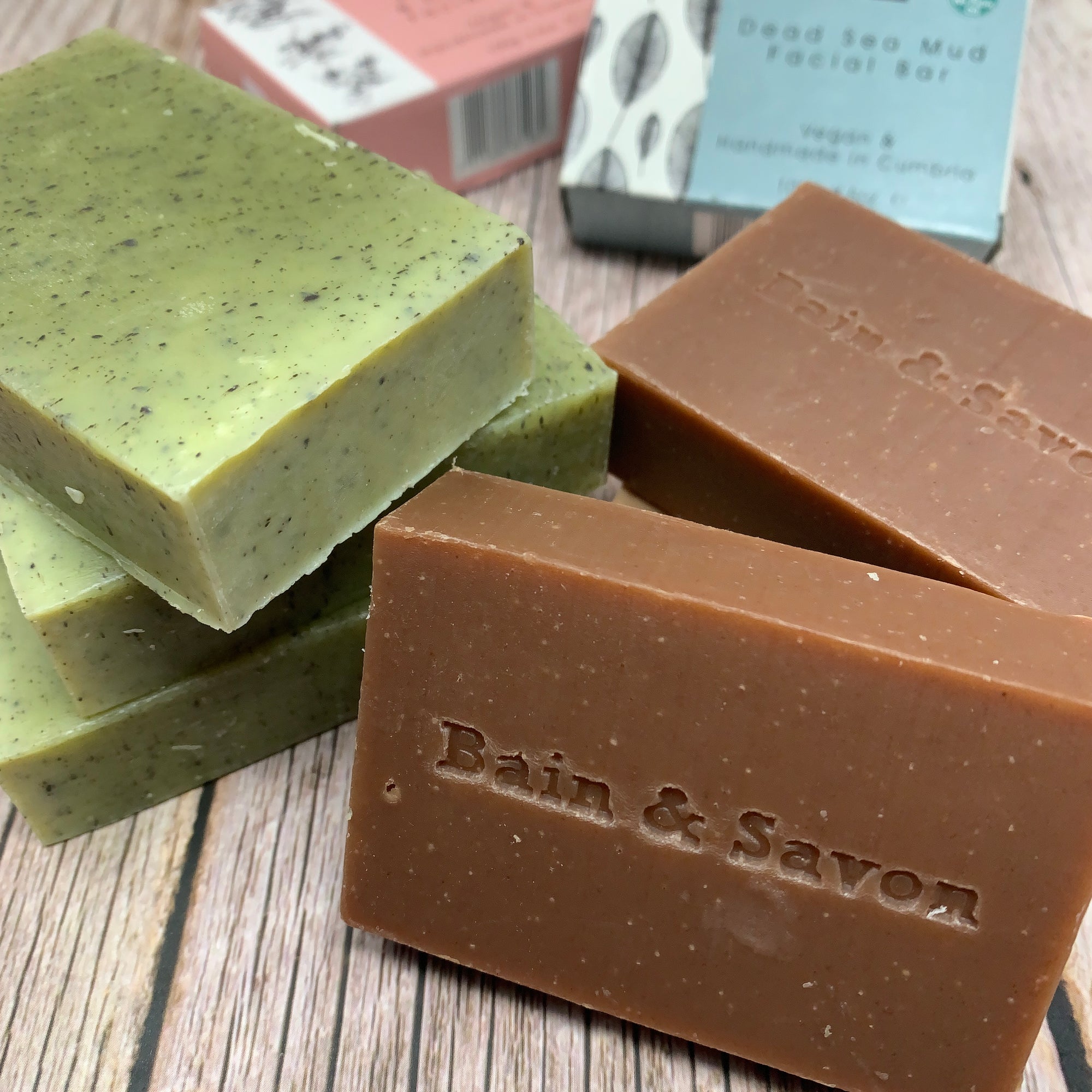 green and brown facial soap bars with bain & savon logo on one of the soaps