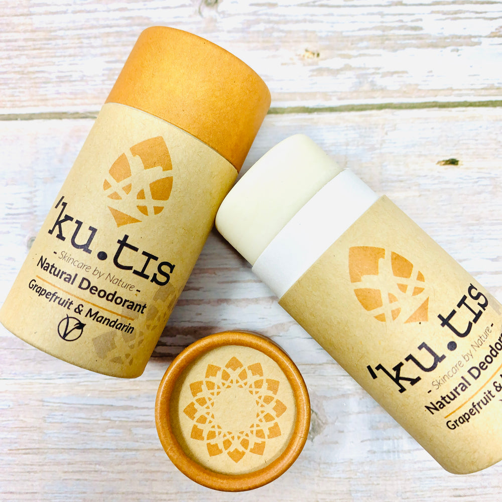two ecofriendly grapefruit and mandarin deodorant sticks by kutis on wooden table